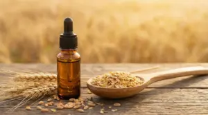 Bottiglietta con contagocce e chicchi di grano su tavolo rustico, con spighe e fiocchi di cereale sullo sfondo